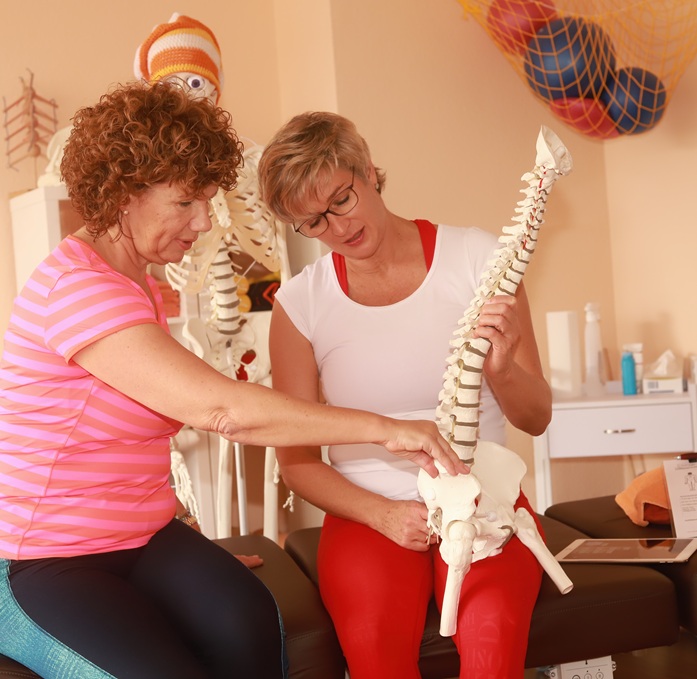 1fach Yoga | 1fach Gesund - Team - Silke Wagner bei therapeutischer Einzelstunde im Gespräch mit Patientin am Skelett