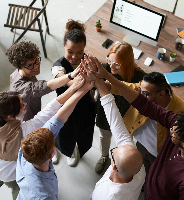 1fach Yoga | 1fach Gesund - Fortbildungen für gesunde Mitarbeiter - eine Gruppe Angestellter im Büro beim Abklatschen